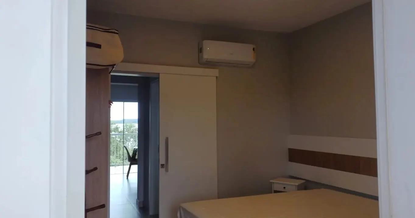 Quarto com ar-condicionado e acesso à varanda