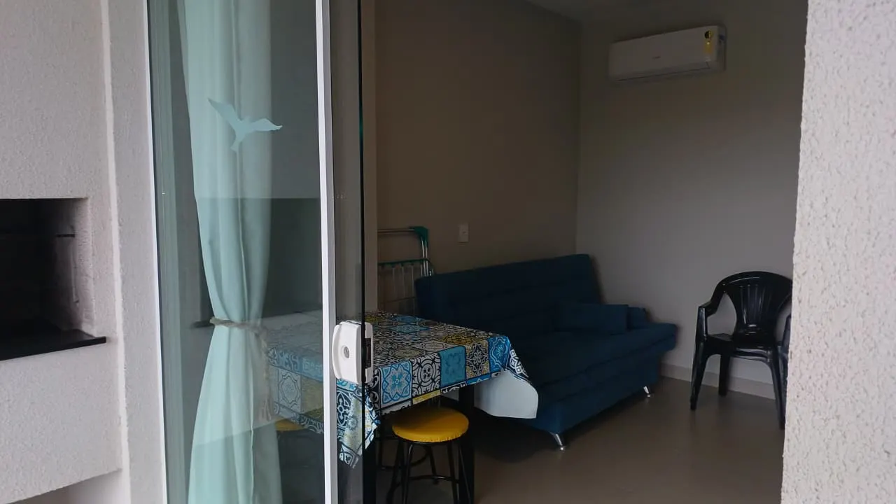 Sacada com sofá e churrasqueira privativa